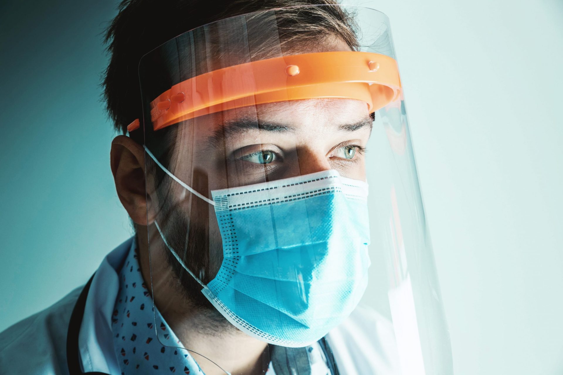 imagen de un medico con una pantalla facial y mascarilla quirurgica