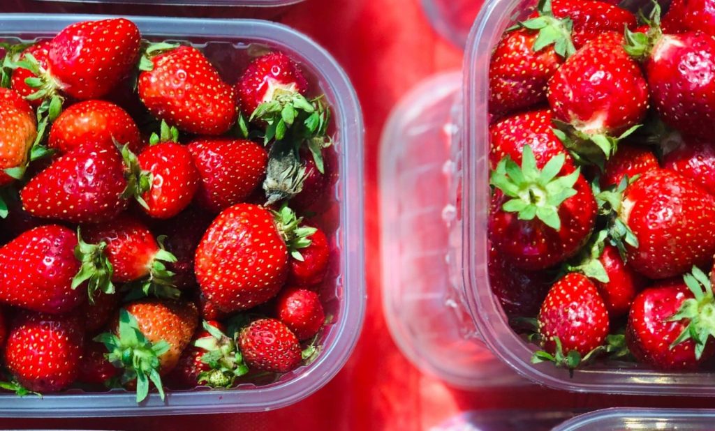 Reglamento (UE) 2022/1616 de plástico reciclado imagen de fresas rojas recogidas en envases de plastico que cumplen el reglamento ue 2022 1616